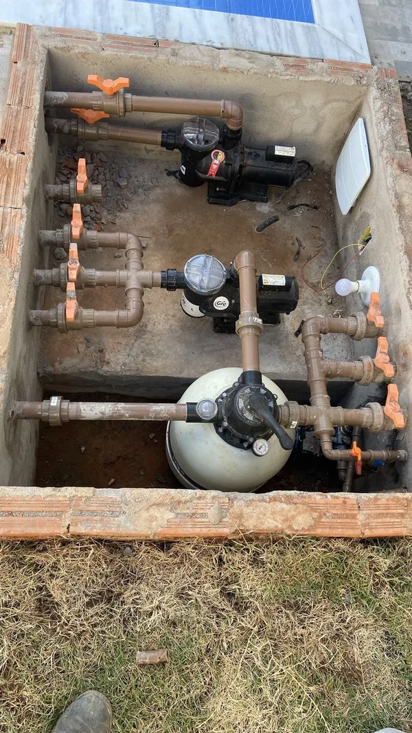 Pool pump, sand filter and valved pipework in a plant pit (illustrative image)